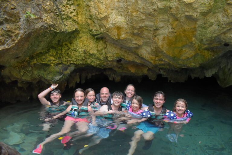 family swimming in cenote, traveling with kids